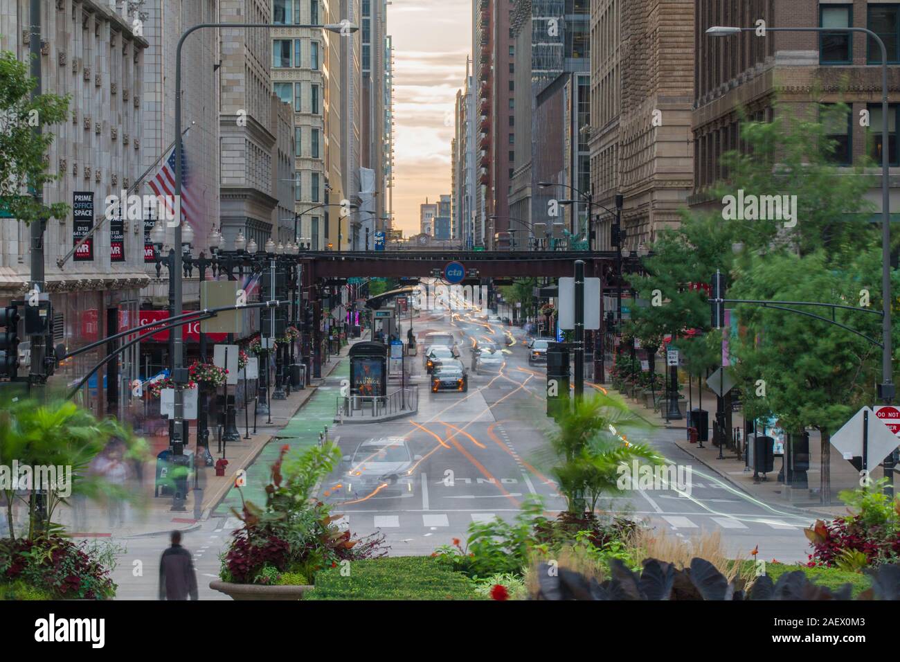 Chicago, USA - Circa 2019: Downtown Chicago day time long exposure of morning street traffic busy movement through road intersection under loop train Stock Photo