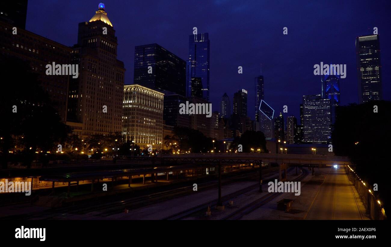Night time establishing shot view of Chicago skyline over a large train