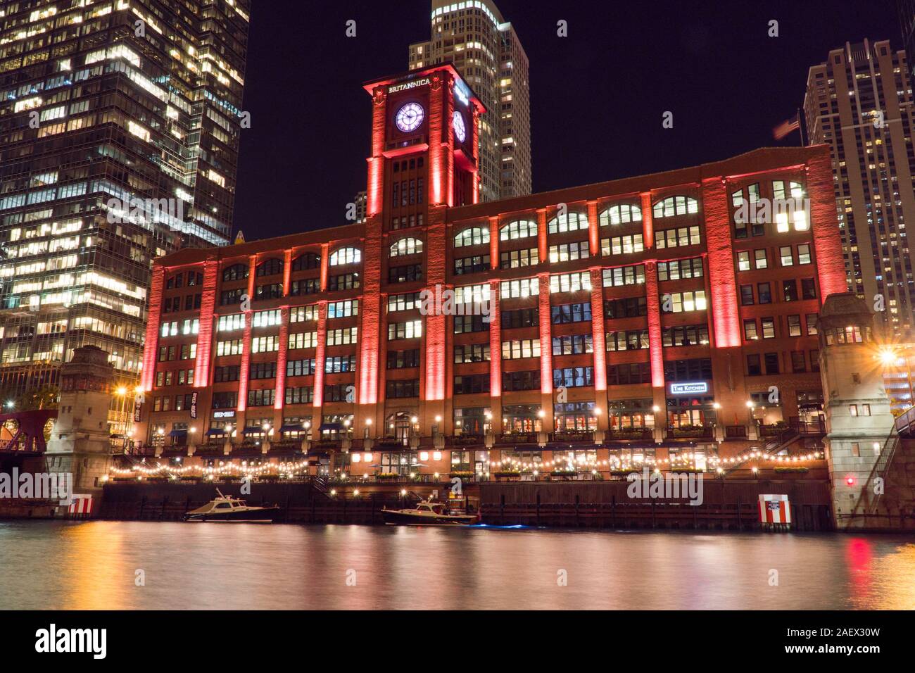 Chicago, IL, Circa 2019: Night time exterior establishing shot of red clock tower Whirlpool building architecture in Chicago along famous river walk Stock Photo
