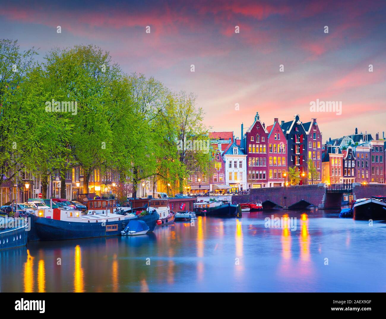 Colorful spring sunset on the canals of Amsterdam. Authentic Dutch architecture in the capital and most populous city of the Netherlands. Stock Photo