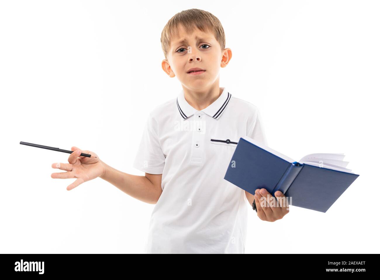 European boy reasoning with a book and pen in his hands on a white background Stock Photo