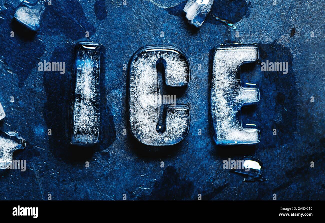 Word ICE made of real ice letters on classic blue background. Stock Photo