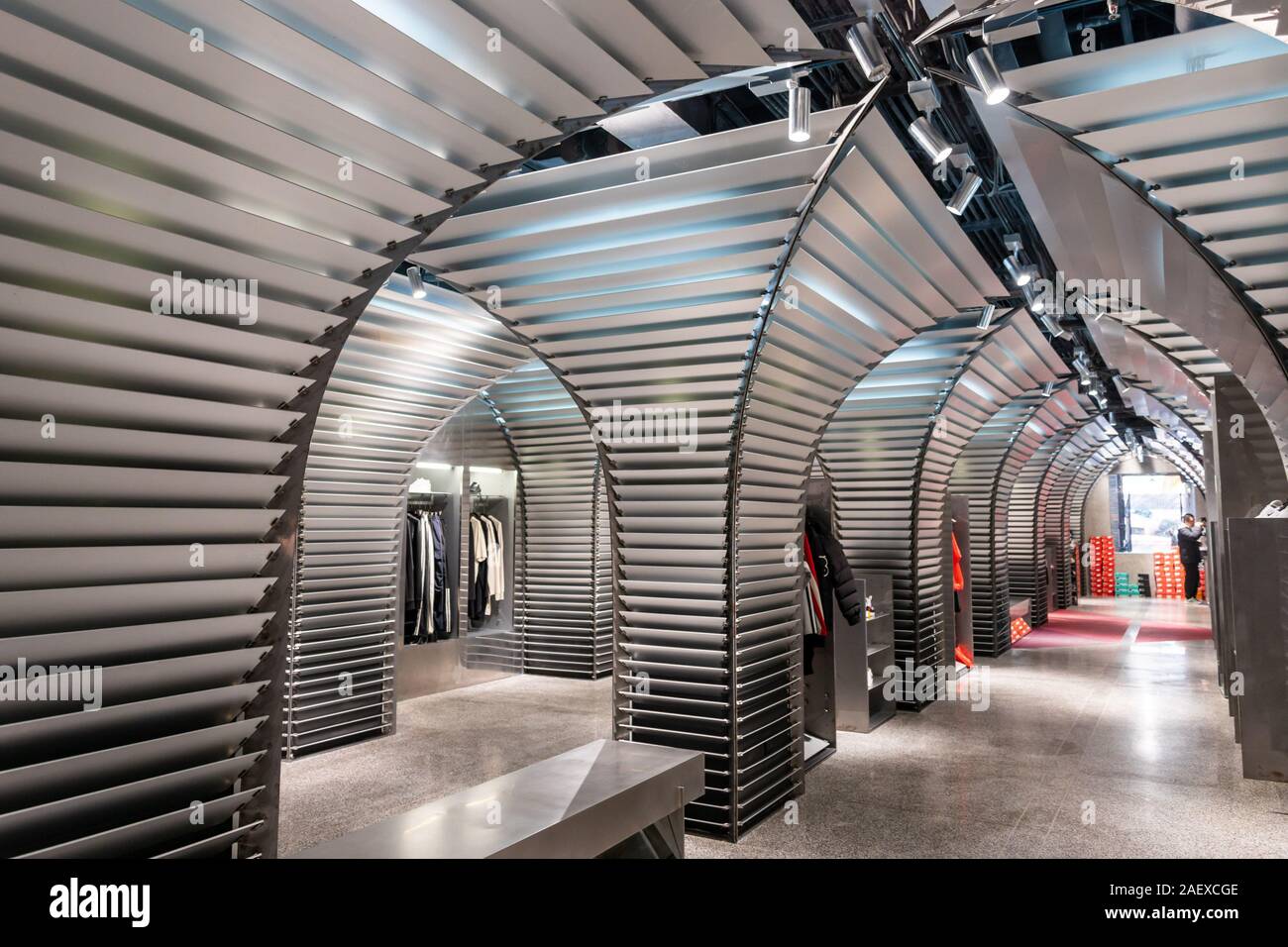 Interior view of a futuristic sportswear store decorated with nodized aluminum materials, metal woven fabric, carbon fiber and terrazzo floor in a Shi Stock Photo