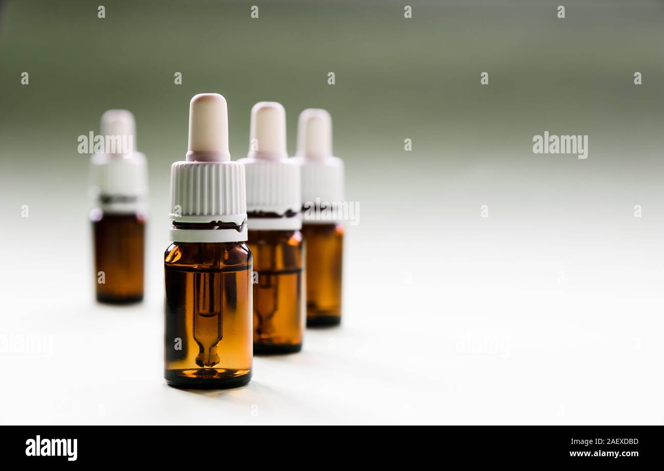 cosmetology, skin care, a row of glass bottles with pipettes and hyaluronic acid inside on a light background Stock Photo