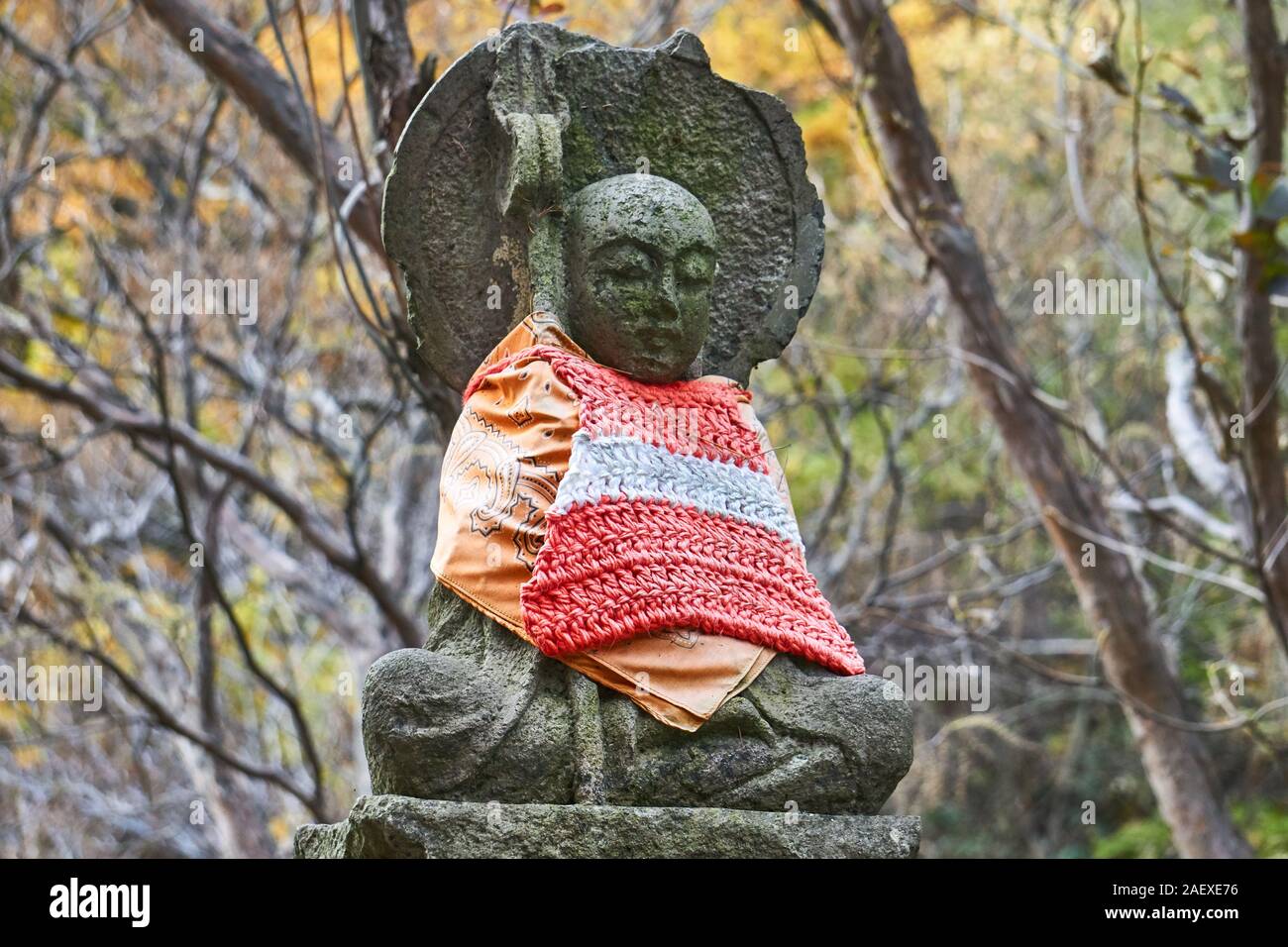 A Jizo statue, made of stone and wearing vibrant hand-knitted, bonnet bib,  and clothing. Jizo is known as a patron deity of deceased children in Japan  Stock Photo - Alamy