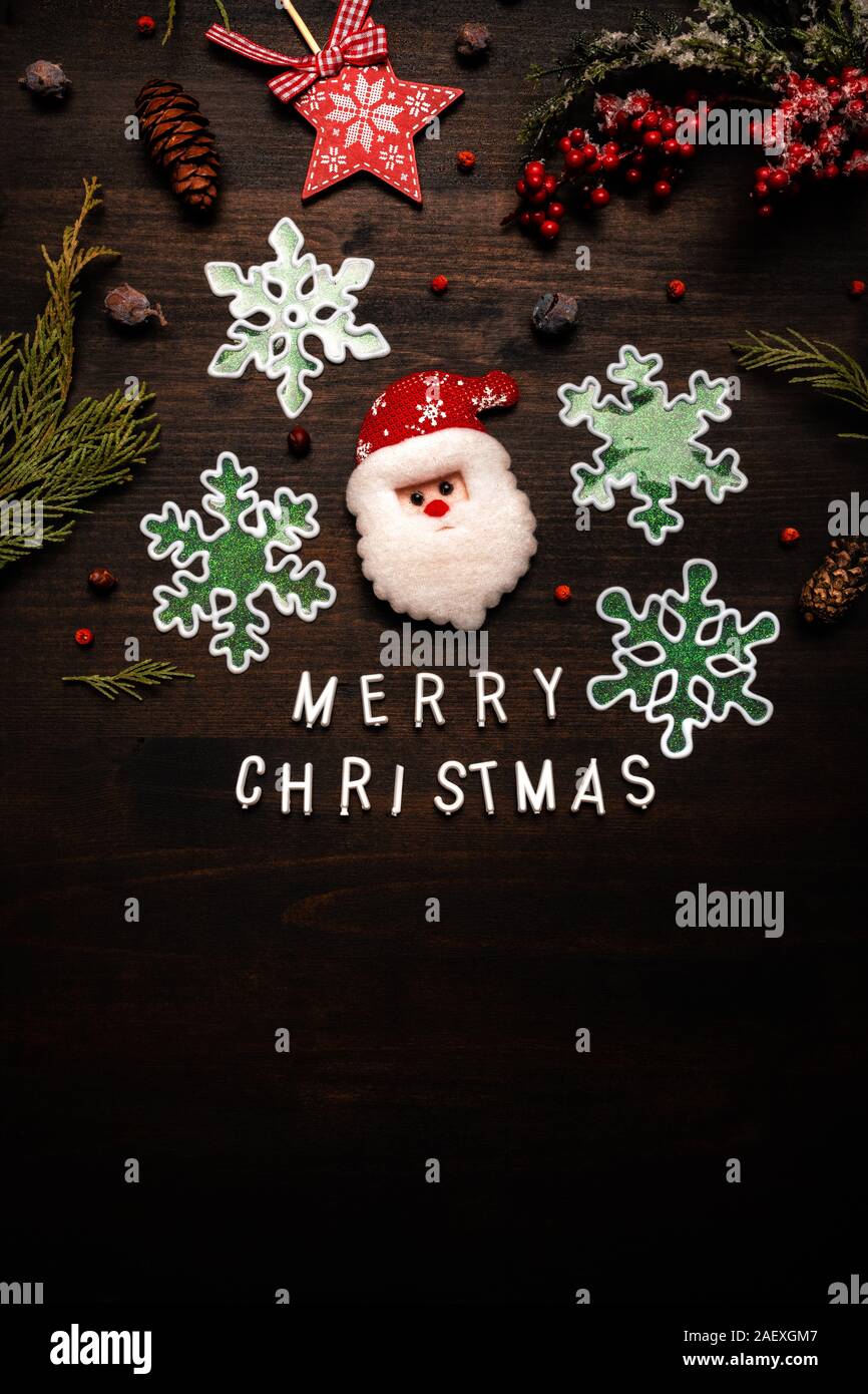 Merry Christmas message flat lay top view with Santa Claus, snowflakes and various Xmas ornaments Stock Photo