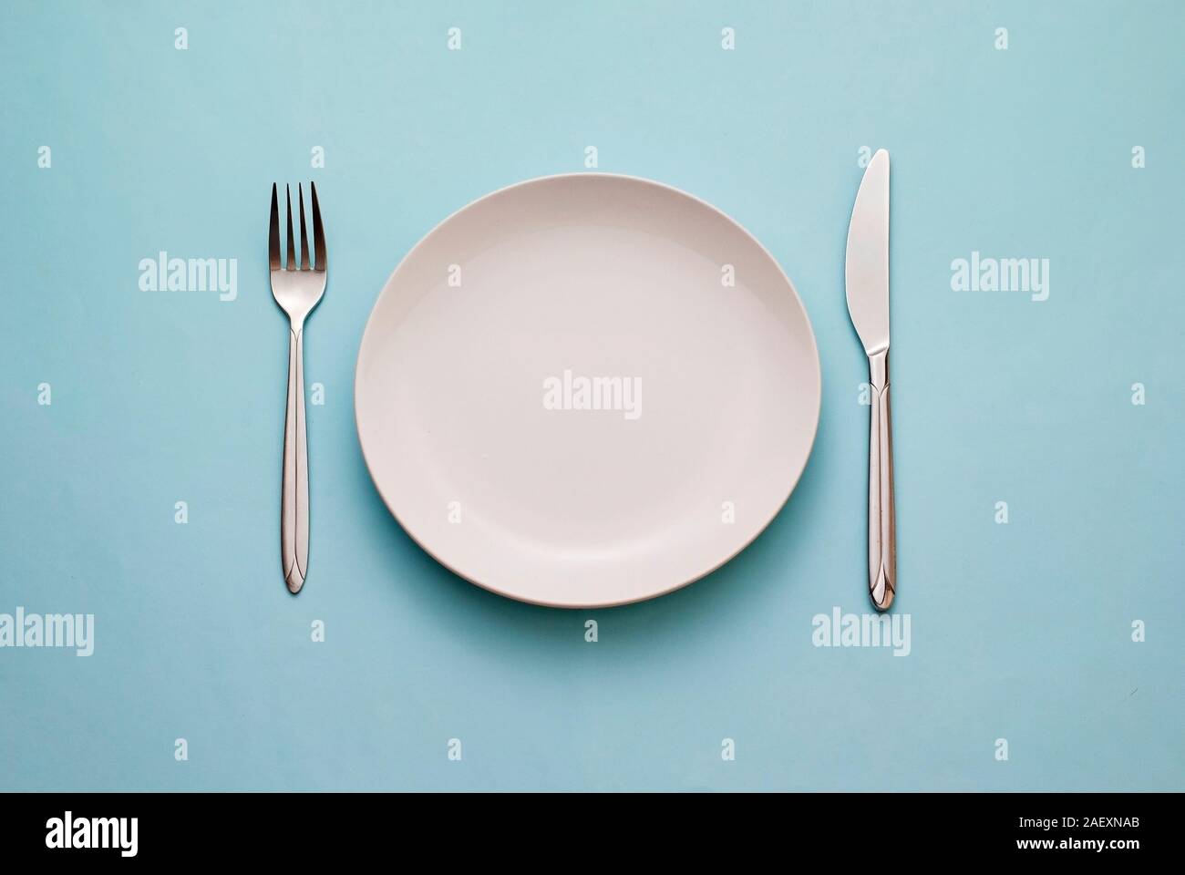 Clean empty white plate with knife and fork Stock Photo