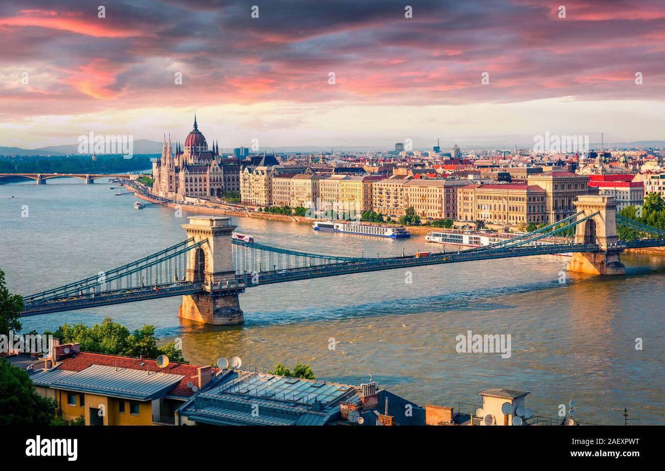 Colorful cityscape of Hungarian parliament building with famous Chain Bridge on the Danube river. Dramatic spring sunset in Budapest, Hungary, Europe. Stock Photo