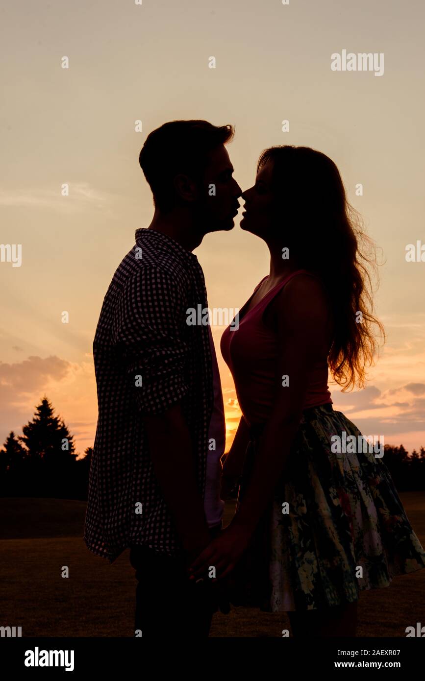 silhouette of couple kissing at sunset Stock Photo - Alamy