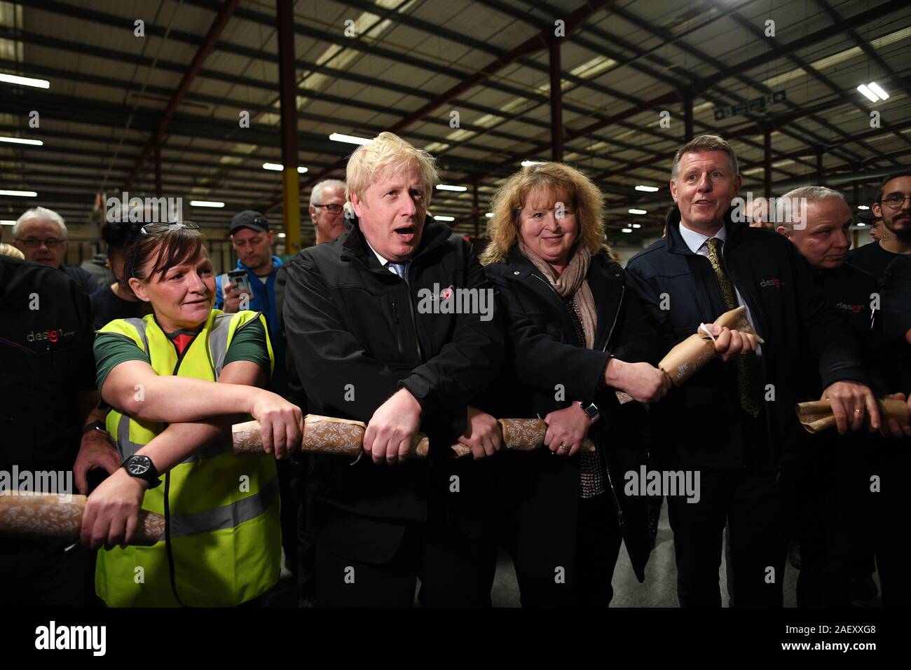 Prime Minister Boris Johnson pulls Christmas crackers with staff during a visit to IG Design Group in Hengoed, on the last day of General Election campaigning. Stock Photo