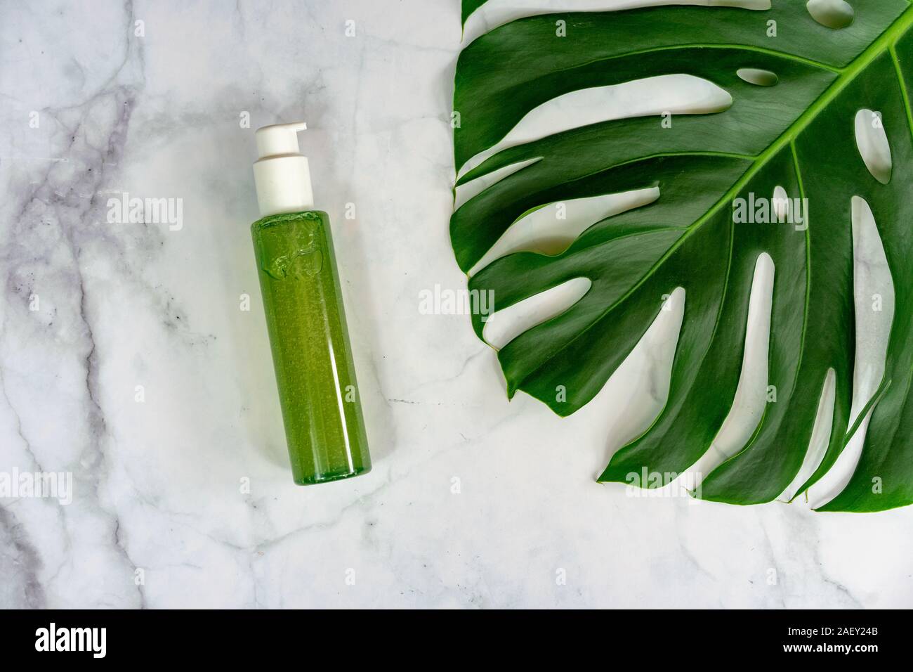 bio cosmetic product on marble background with leaves . Stock Photo