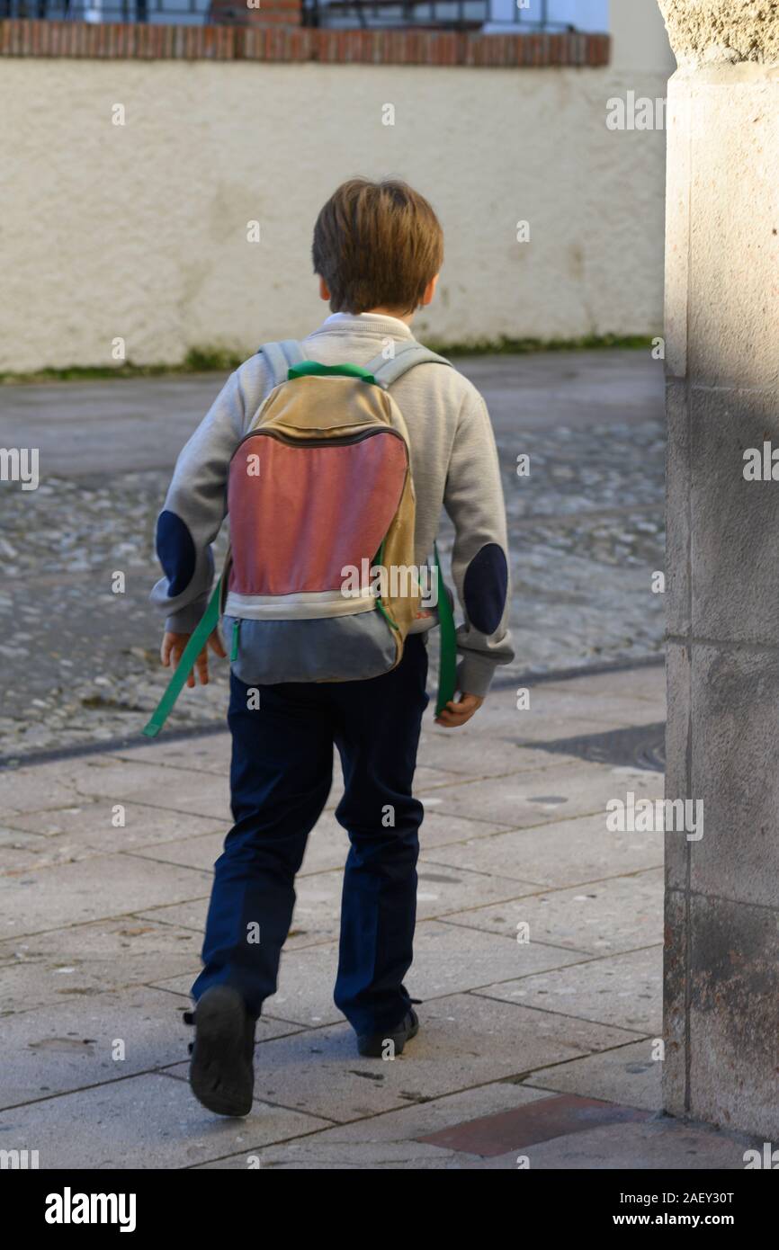 Rear view of boy with a backpack walking, Spain Stock Photo - Alamy