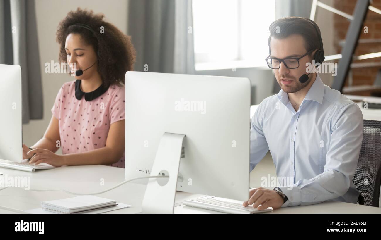 Diverse operators in headphones work on pc consulting clients Stock Photo