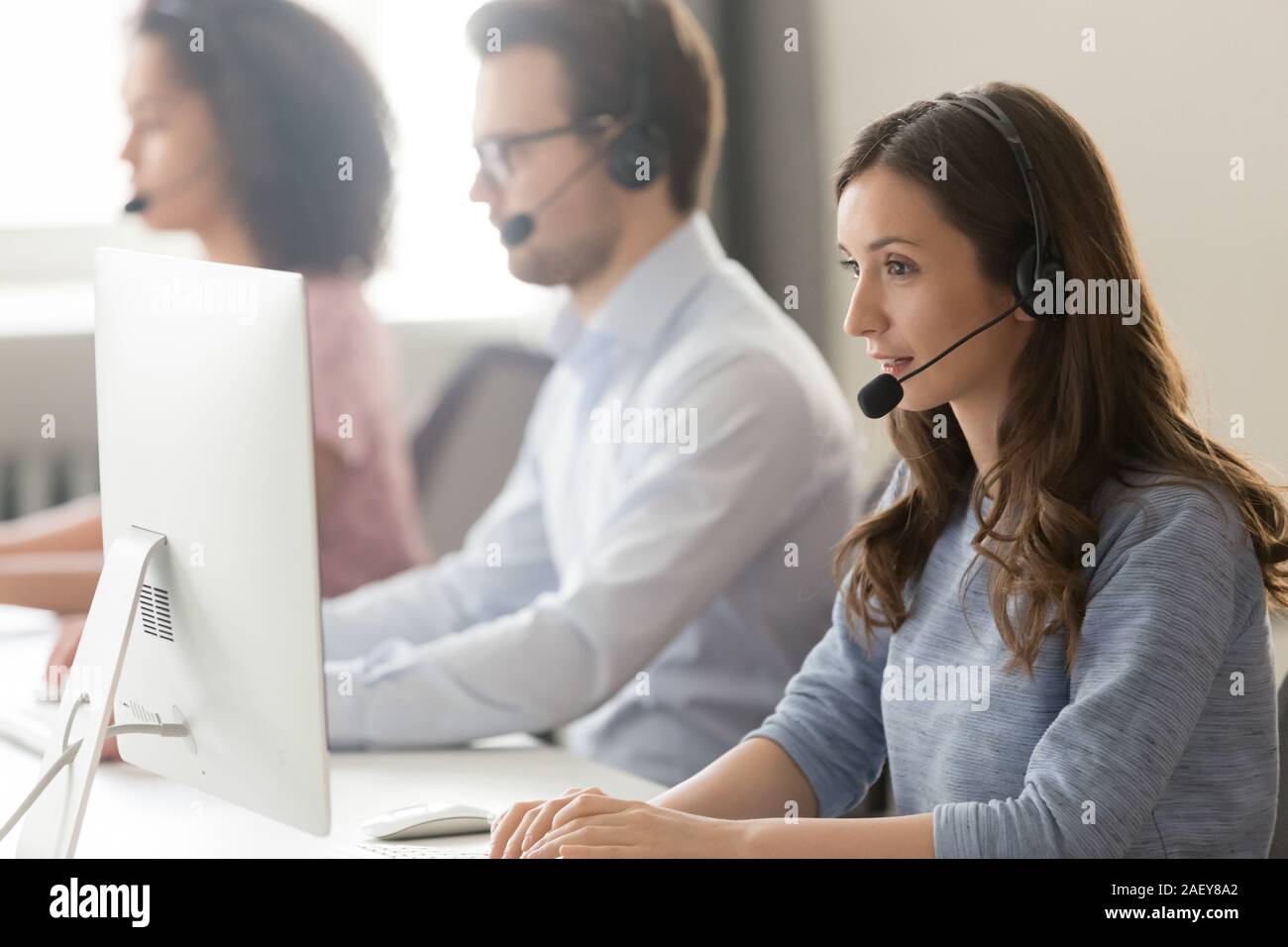 Female agent in headset consult client online using pc Stock Photo