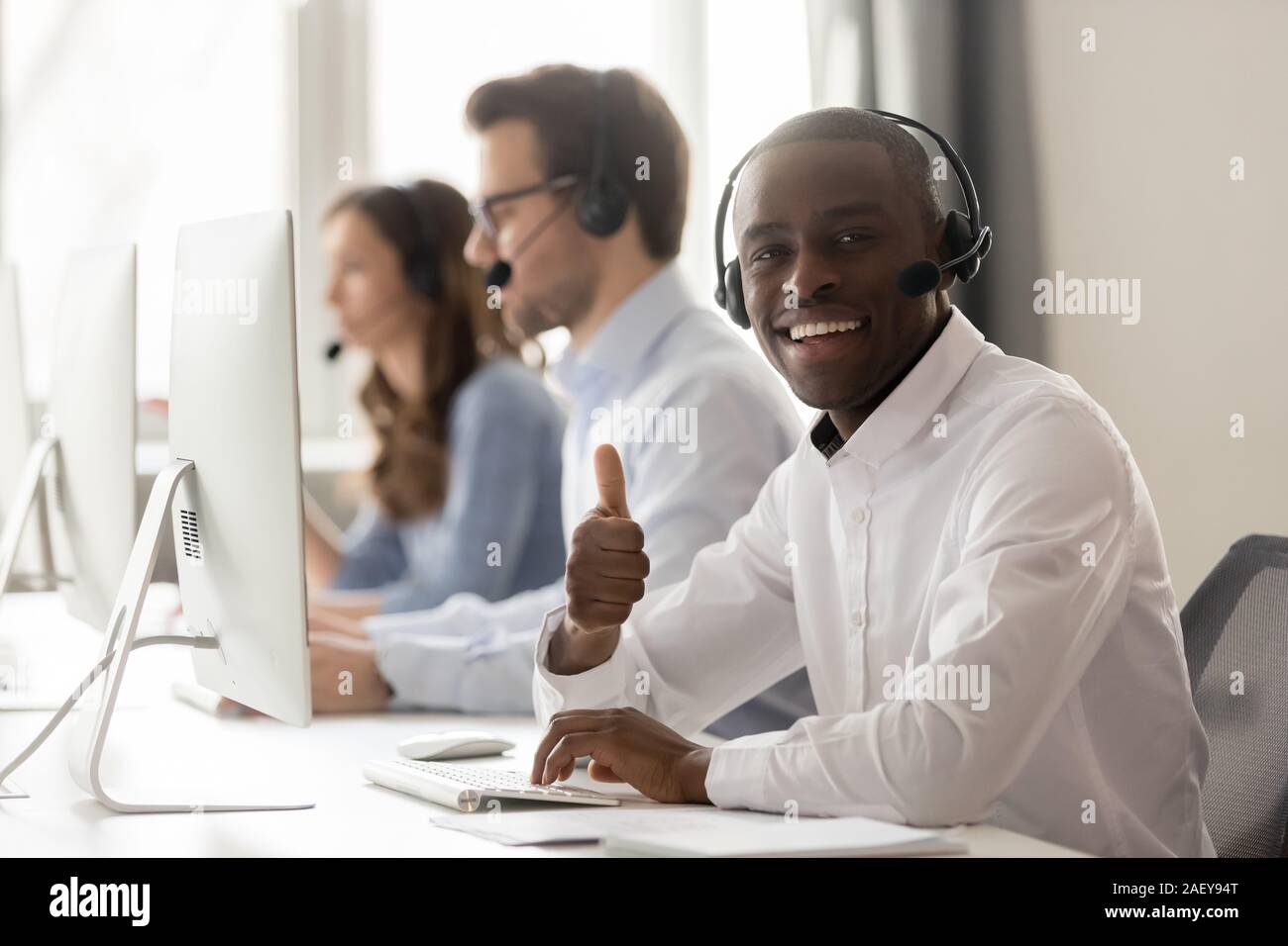 Smiling black operator show thumbs up recommending service Stock Photo