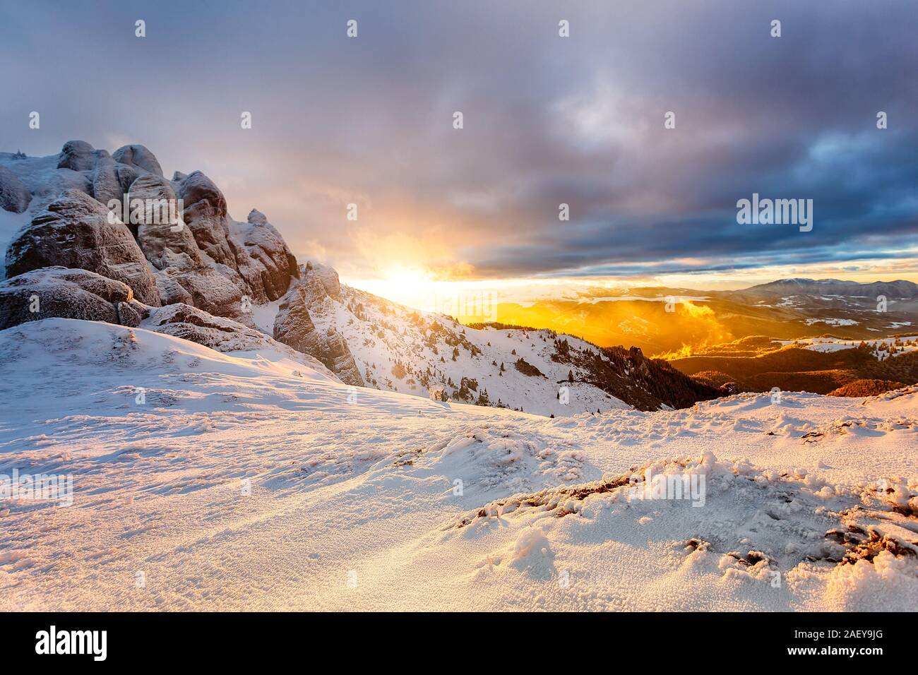 Winter mountain Sunset. Beautiful winter landscape at sunset with clouds and snow over the mountain cliffs. Stock Photo