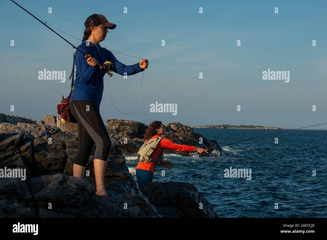 https://c8.alamy.com/comp/2AEYCJ0/two-young-women-fly-fishing-for-striped-bass-on-a-summer-afternoon-in-maine-2AEYCJ0.jpg