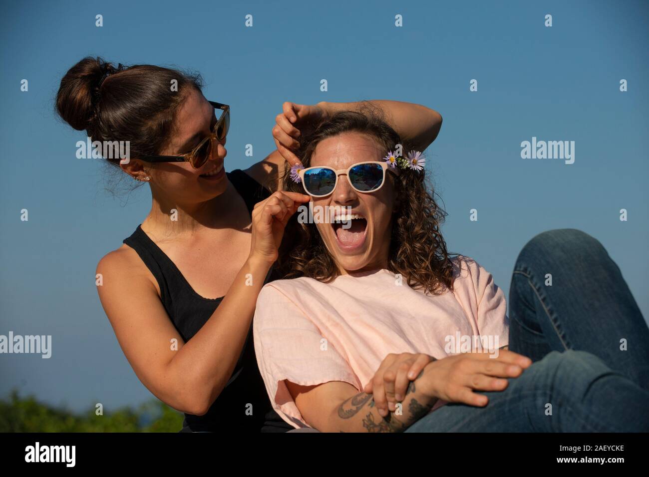 Two women laughing outside on a sunny day. Stock Photo