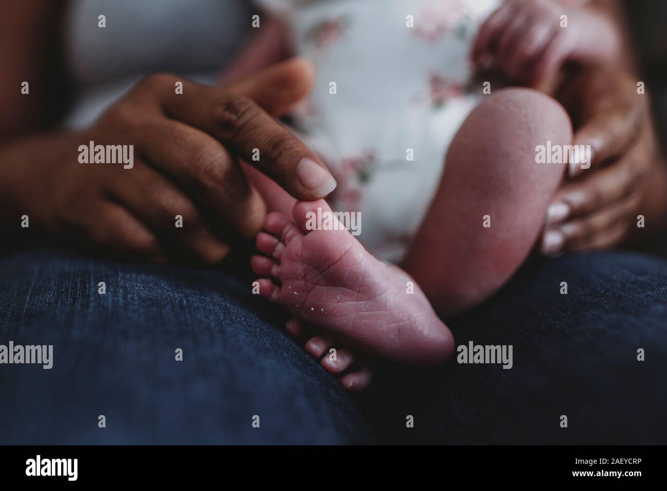 Ethnic momâ€™s index finger touching newbornâ€™s tiny foot Stock Photo