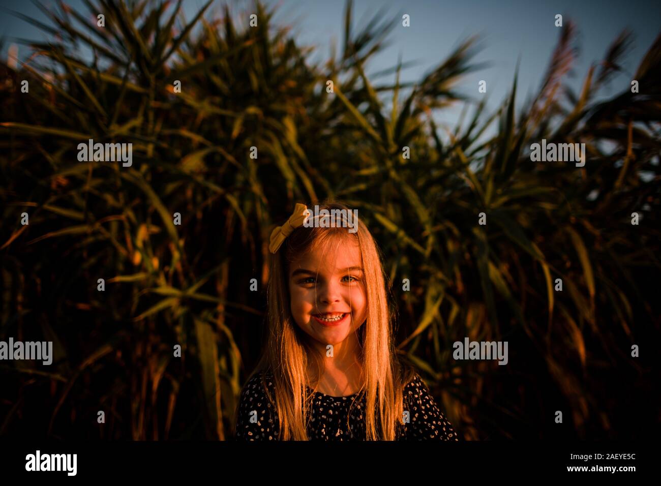 Young Girl Smiling at Camera During Sunset Stock Photo - Alamy