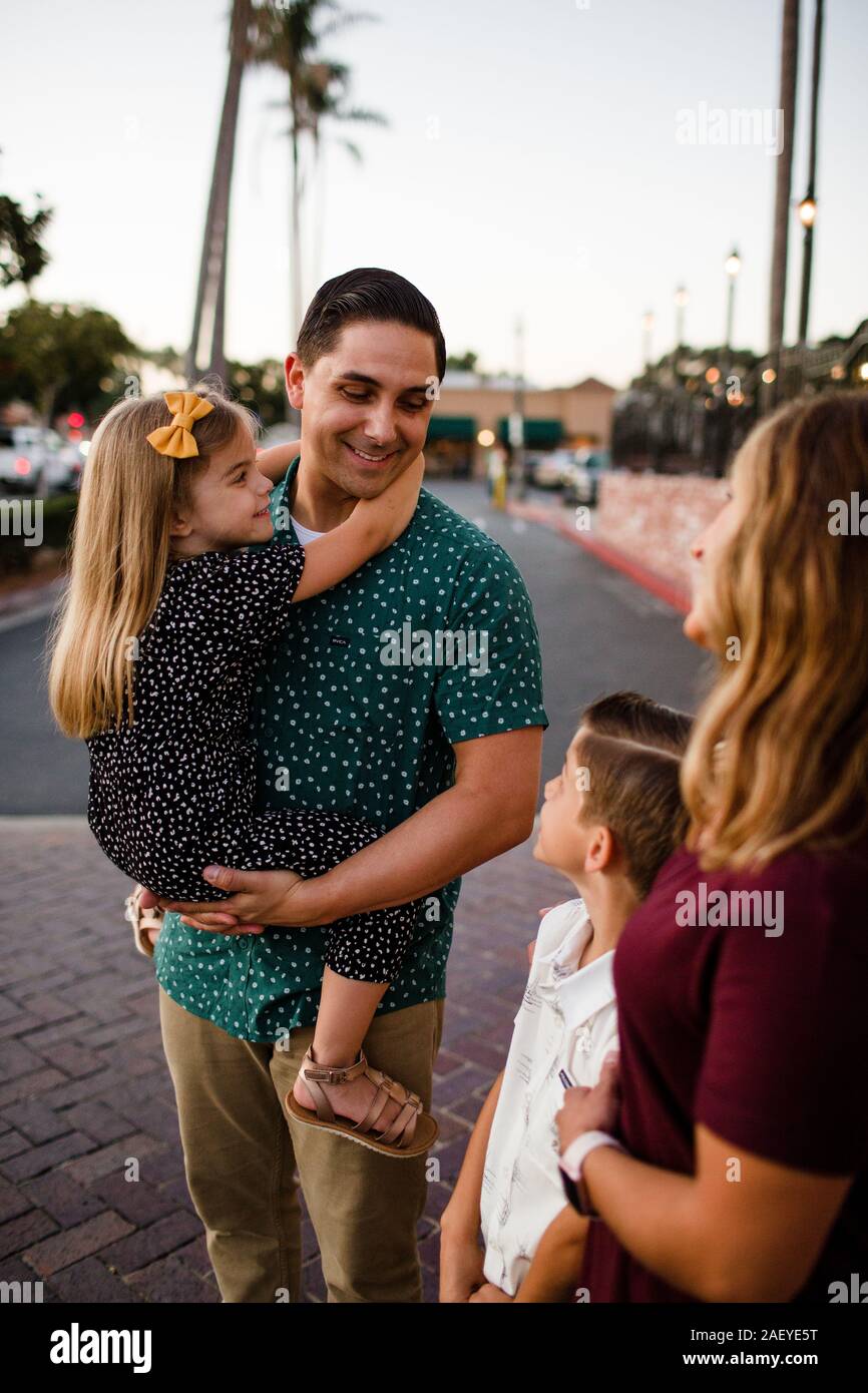 Father Holding Daughter & Smiling at Son Stock Photo