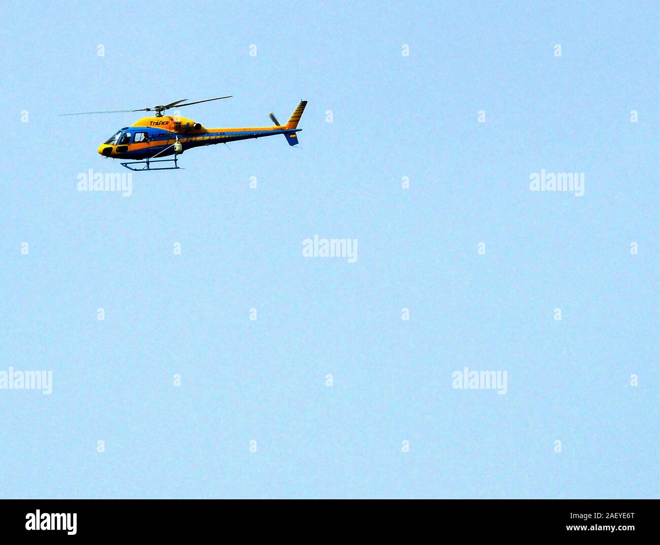 A Spanish traffic surveillance helicopter (Trafico) on duty over the Costa del Sol coastline 2017, picked out against a clear blue sky. Tráfico’s helicopter unit is the oldest in Spain (founded in 1964) Stock Photo