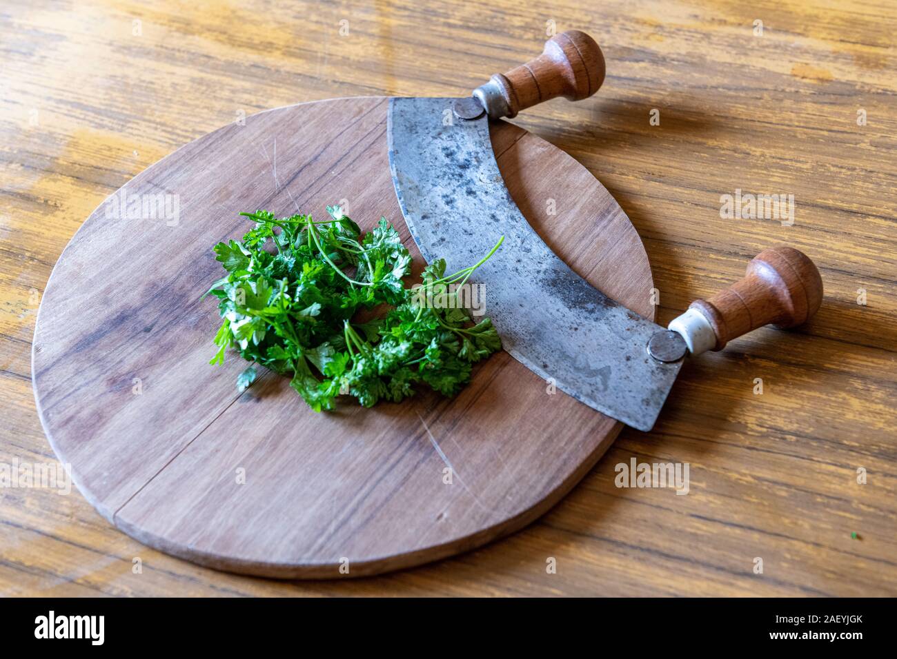 https://c8.alamy.com/comp/2AEYJGK/onion-parsley-and-chopper-on-a-wooden-board-in-a-kitchen-2AEYJGK.jpg