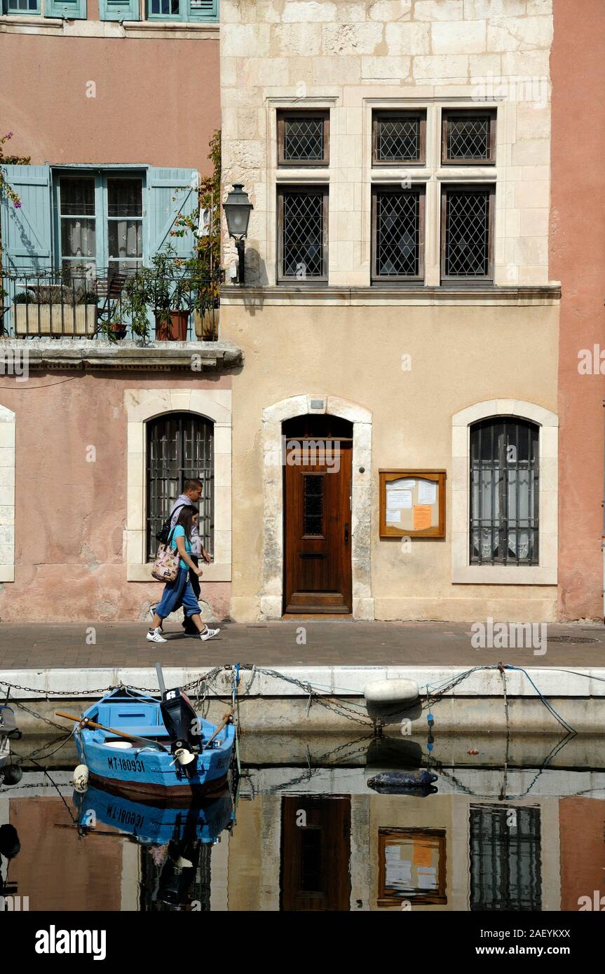 Couple of Tourist Walking Past Traditional Canalside House or Waterfront House overlooking Miroir aux Oiseaux Canal Basin Martigues Provence France Stock Photo