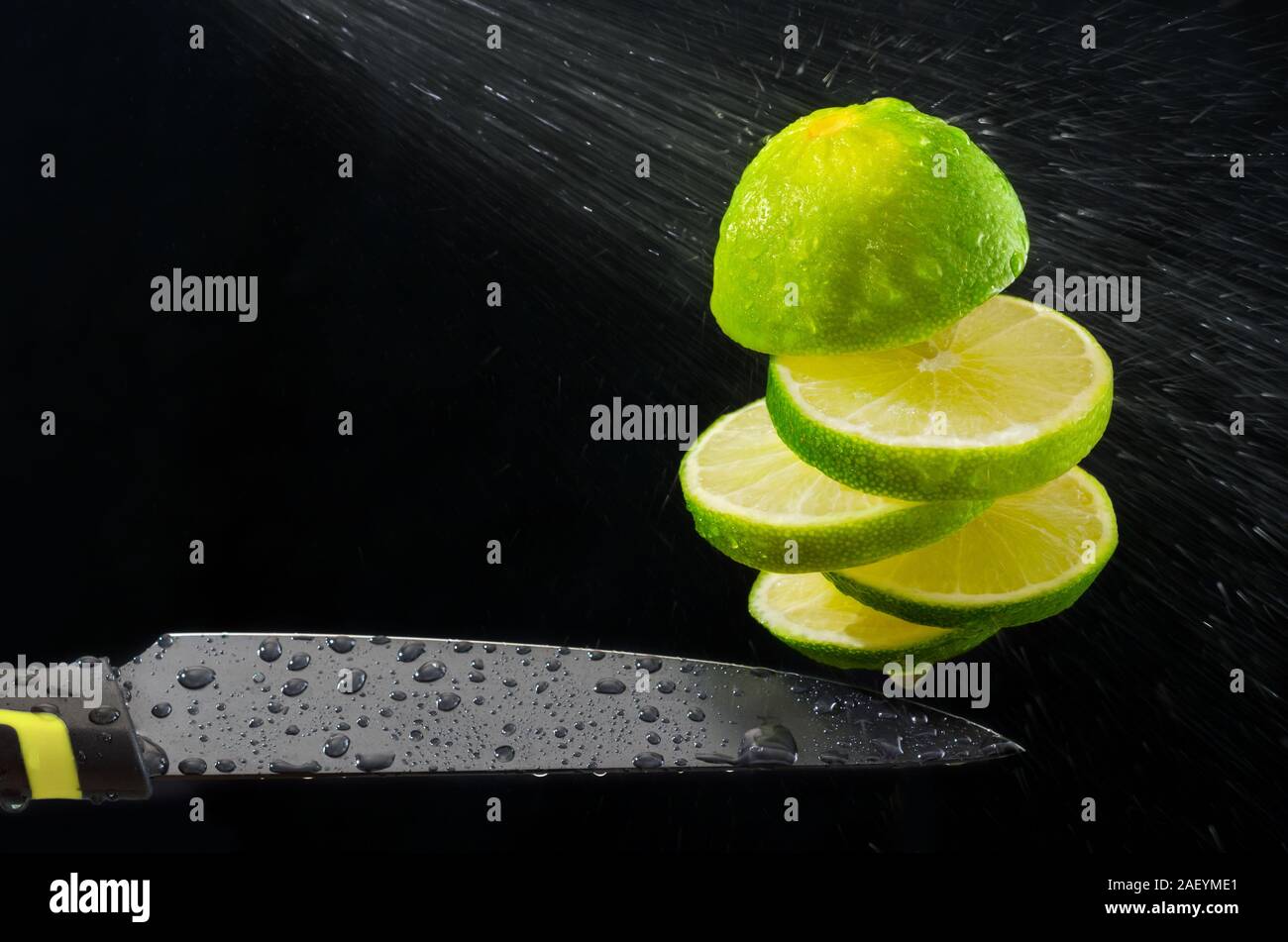 Wash and slice the lime on the fly. Stock Photo