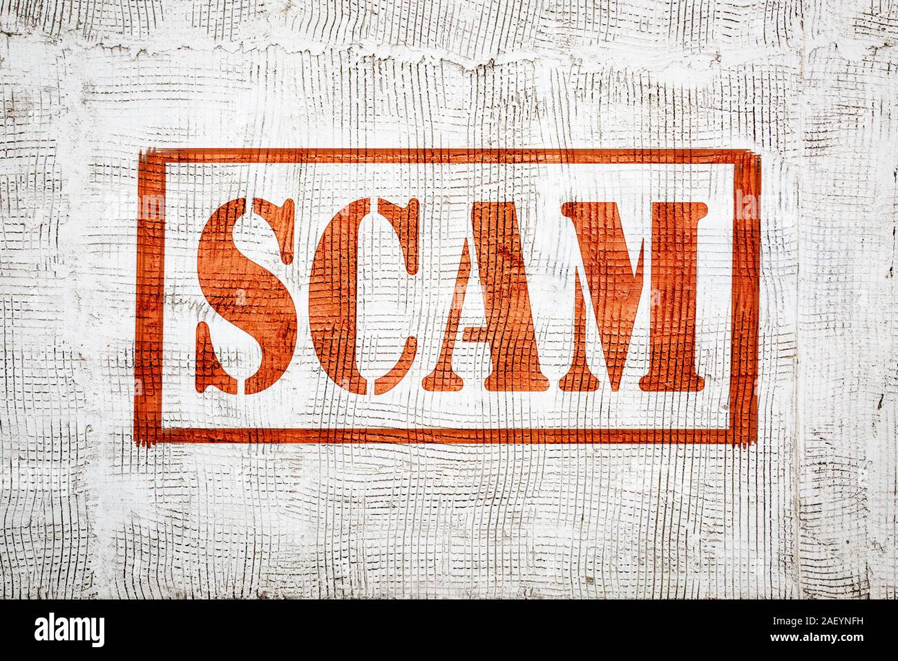 scam - red graffiti style sign on a white stucco wall, dishonest scheme or fraud concept Stock Photo