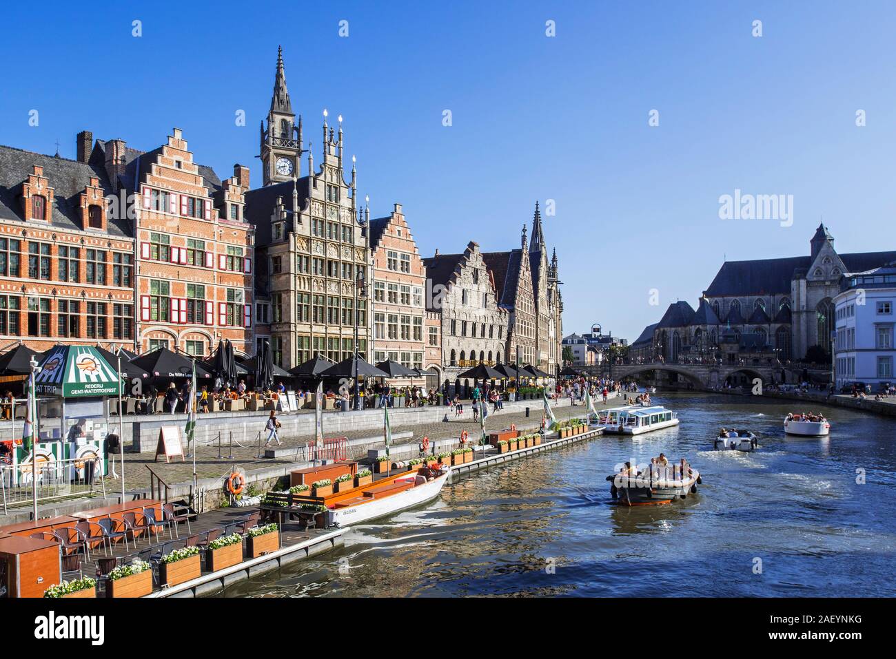 Sightseeing boats with tourists on the river Lys with view over guildhalls at the Graslei / Grass Lane in the city Ghent, East Flanders, Belgium Stock Photo
