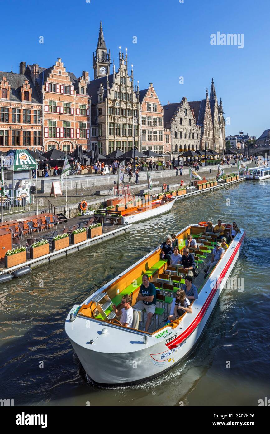 Sightseeing boat with tourists on the river Lys with view over guildhalls at the Graslei / Grass Lane in the city Ghent / Gent, East Flanders, Belgium Stock Photo