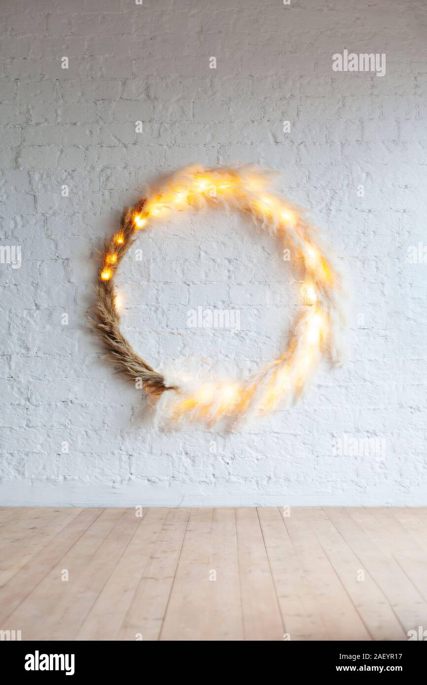 Incredible Scandinavian-style decorative ring on a white wall with dry plant lighting Stock Photo