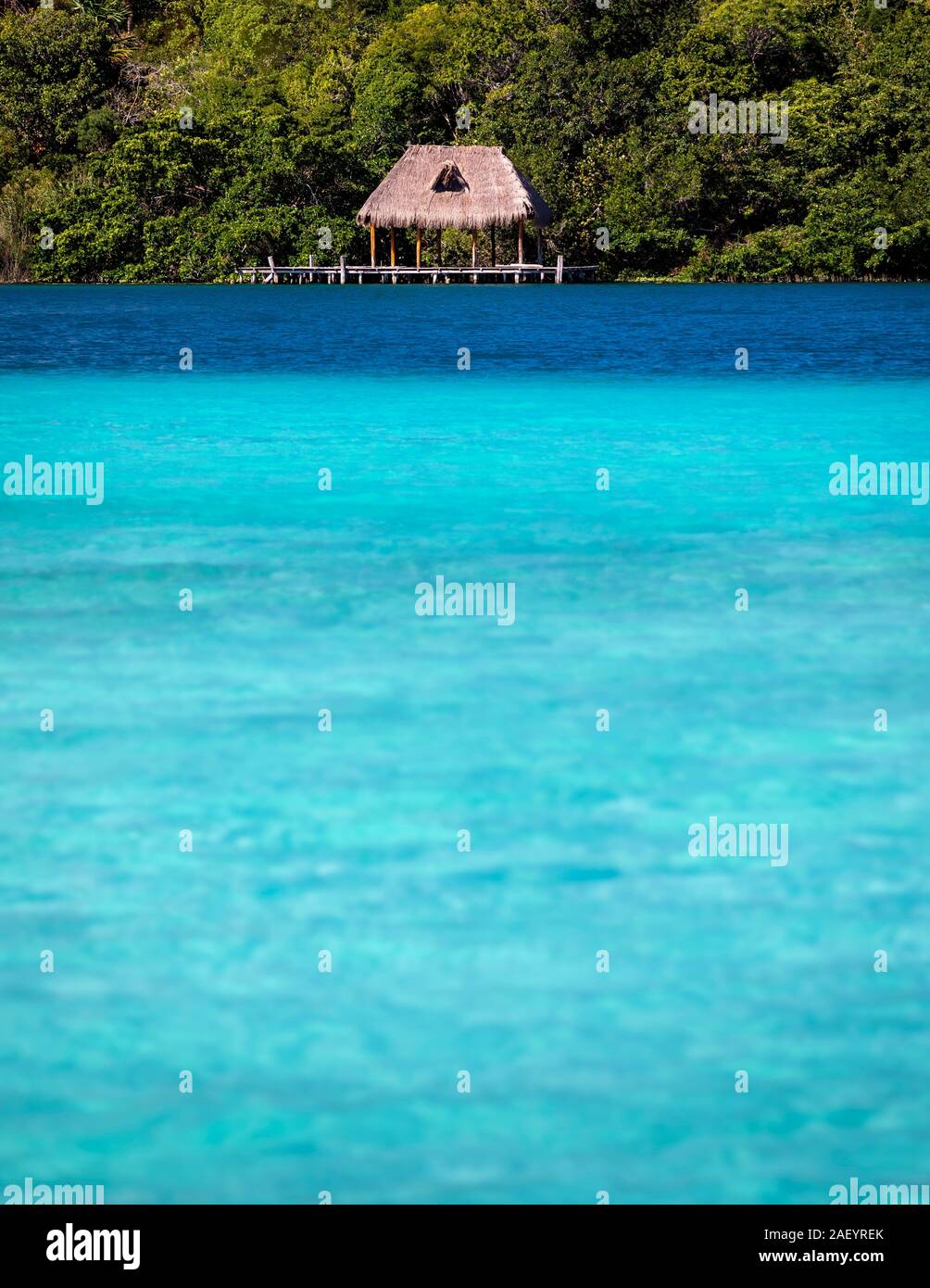 A palapa on the 'lake of seven blues' in Bacalar, Quintana Roo, Mexico. Stock Photo