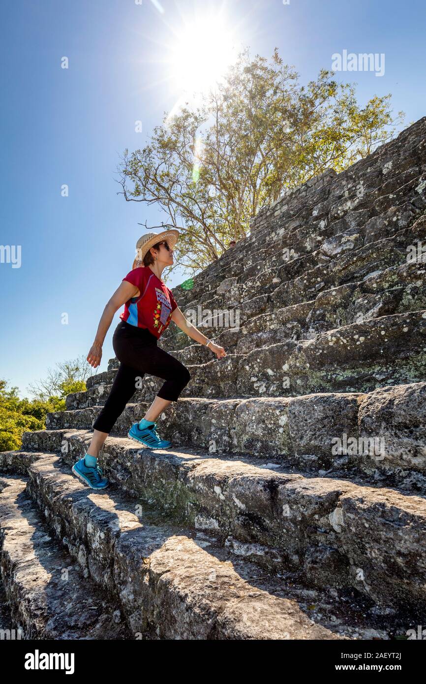 A female tourist scales the main pyramid (Structure II) at Calakmul Archaeological Site in Campeche, Mexico. Stock Photo