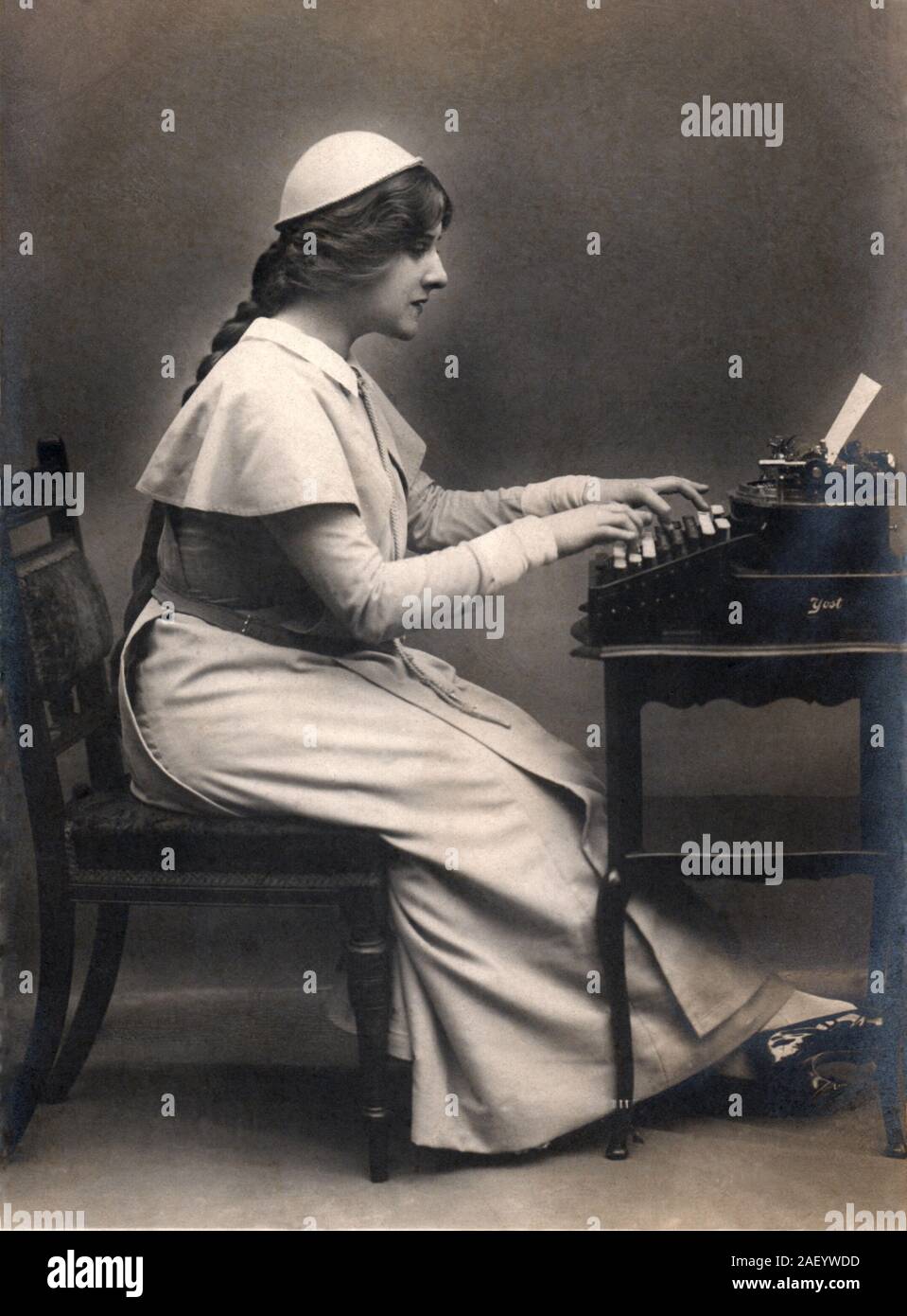 Secretary circa 1907 using a Yost typewriter from the late 1800s, vintage real photographic postcard (RPPC.) Stock Photo