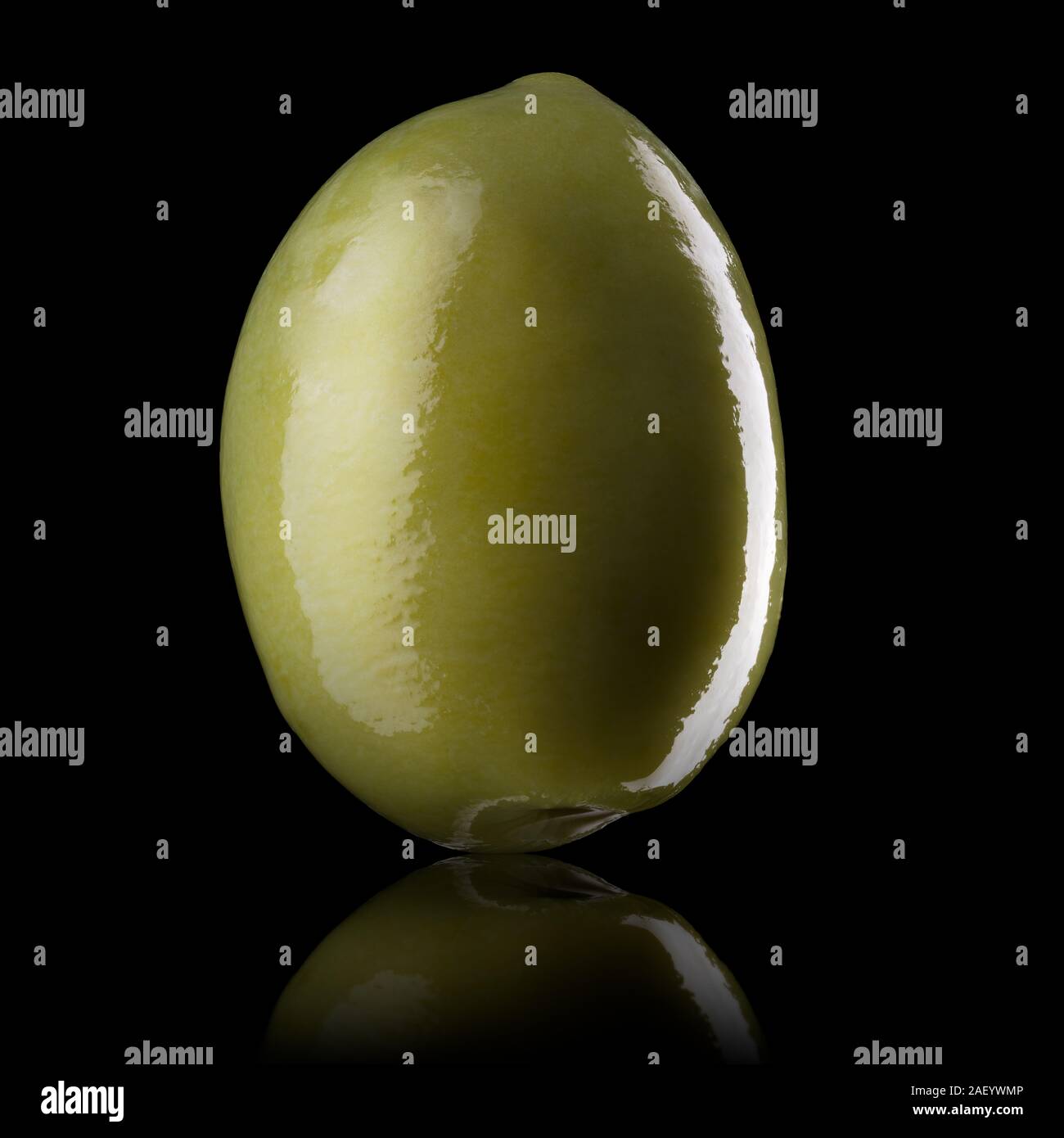 Macro photo of green olive with reflection of light isolated on a black