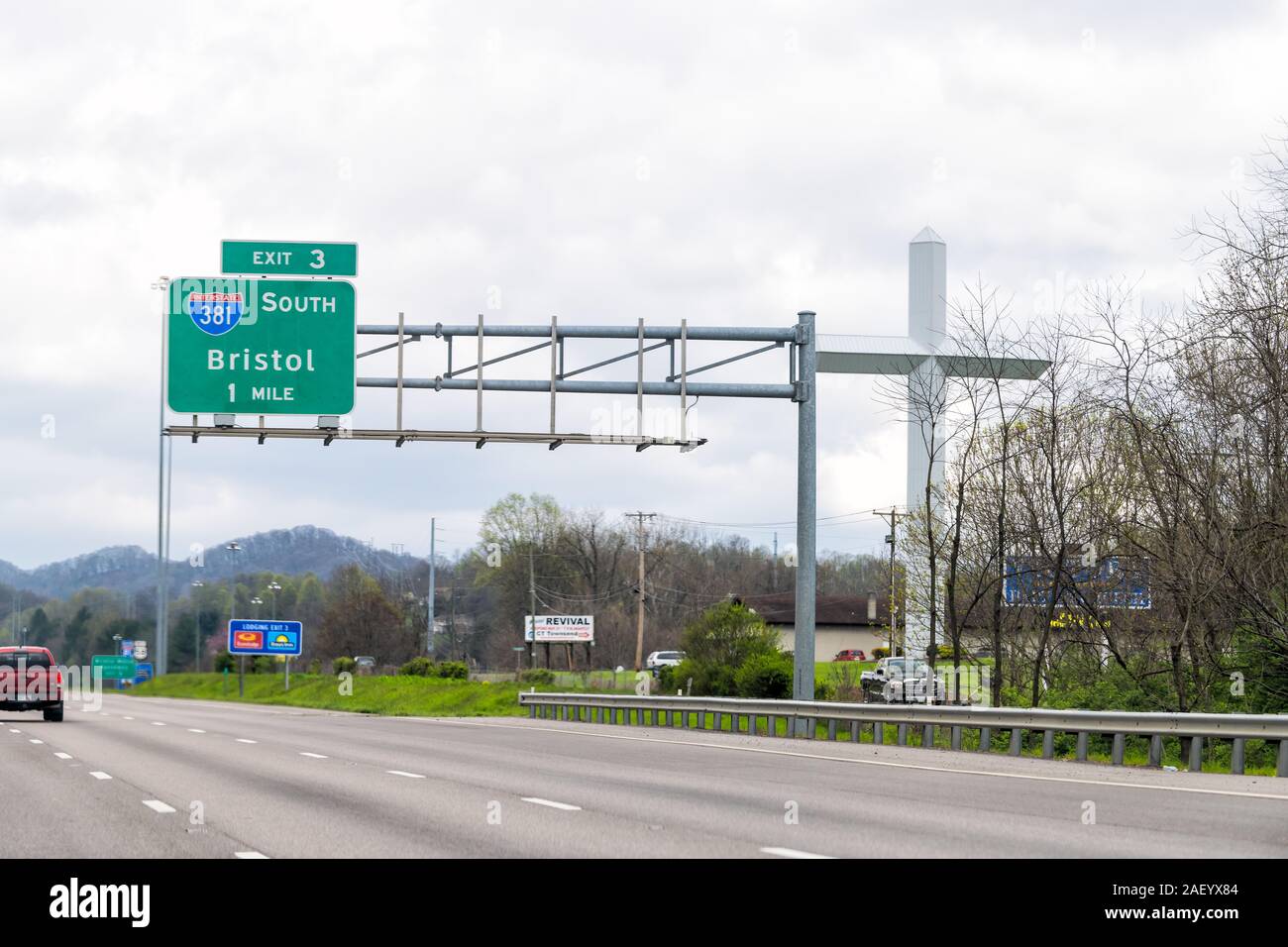 Bristol, USA - April 19, 2018: Small town exit sign in Virginia on interstate 381 or 81 with big large cross by church and traffic cars Stock Photo