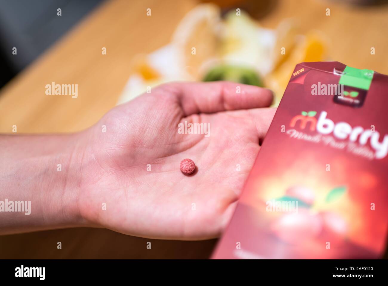 Durango, USA - September 2, 2019: Hand holding mberry miracle berry ledidi Synsepalum dulcificum berry brand tablet that turns sour foods sweet Stock Photo