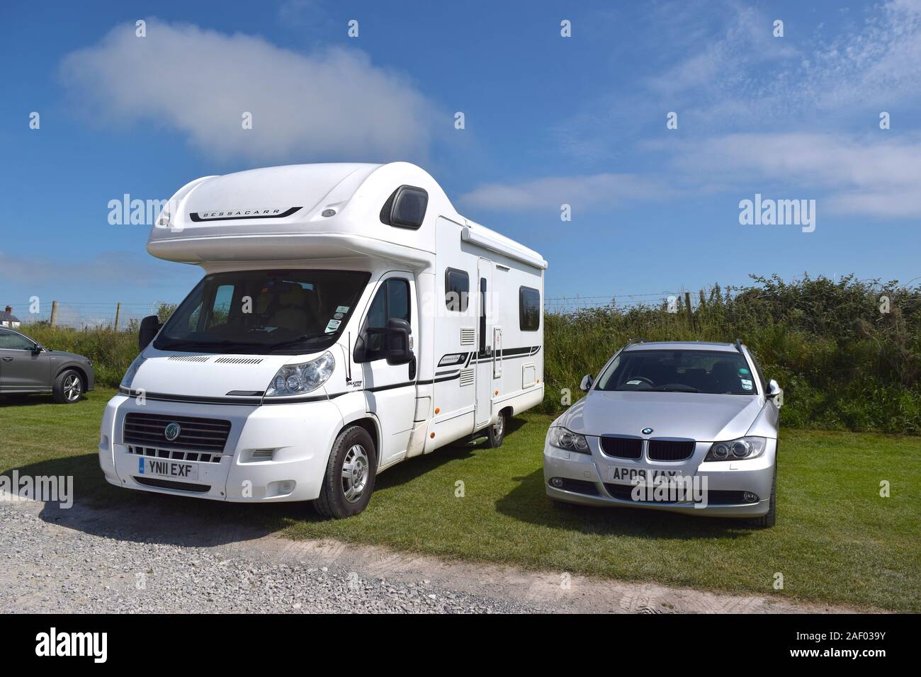 White spacious camper van and cars parked on the beach car park. Stock Photo