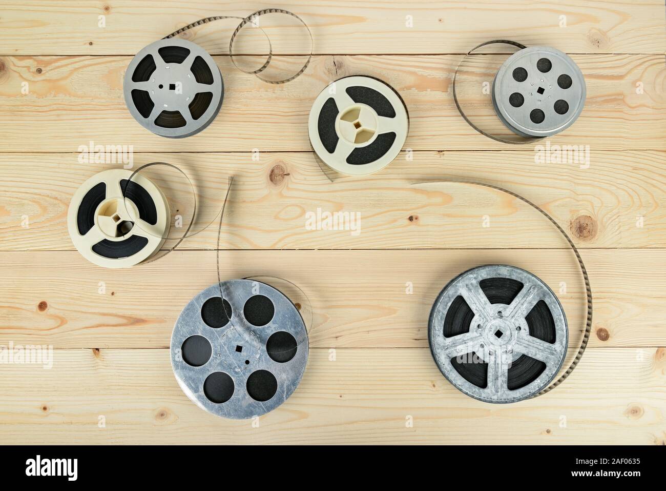 Reels with film on light wooden background Stock Photo