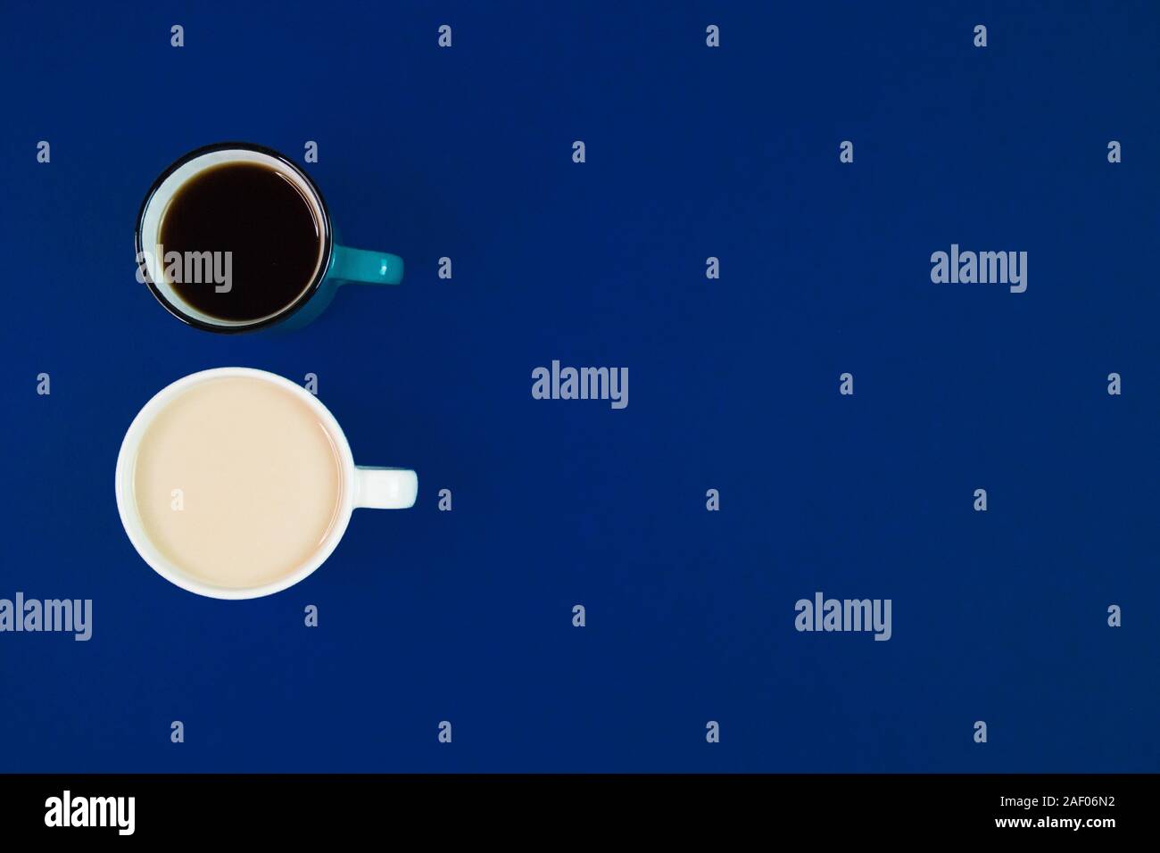 Two cups with different kinds of coffee on a blue background with empty space, minimalistic composition with hot beverages, top view. Stock Photo