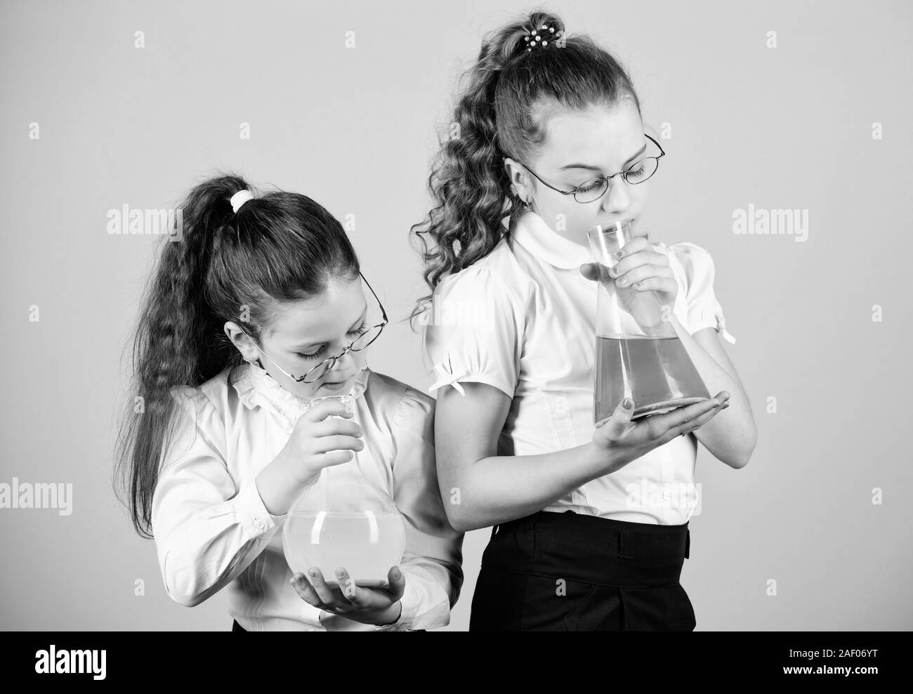 children study at biology lesson. little smart girls with testing flask. knowledge and education. science research in lab. back to school. study chemistry. they love study. small girls study at home. Stock Photo