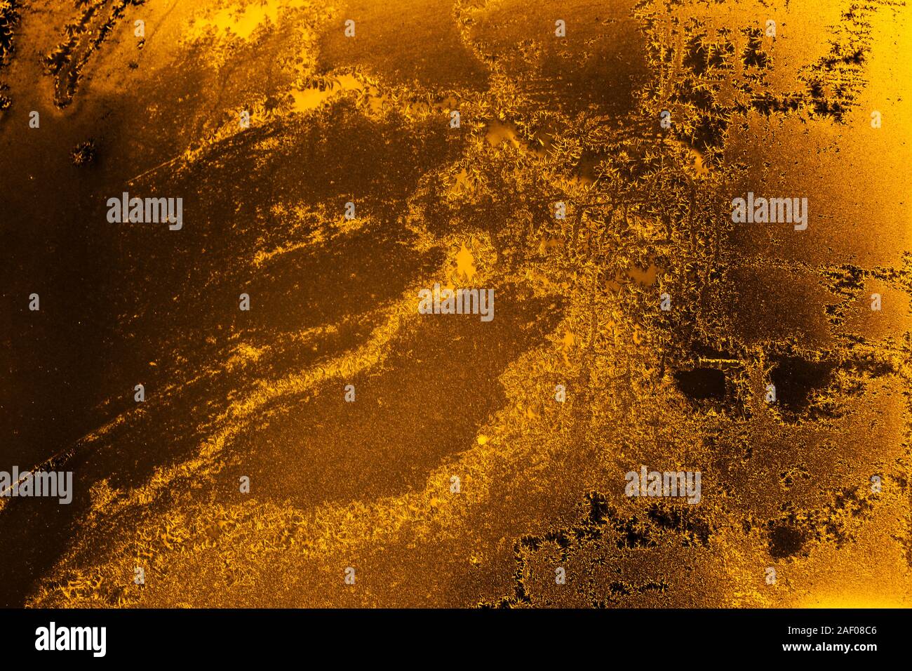 Amber colored background with ice textures of different shades of amber
