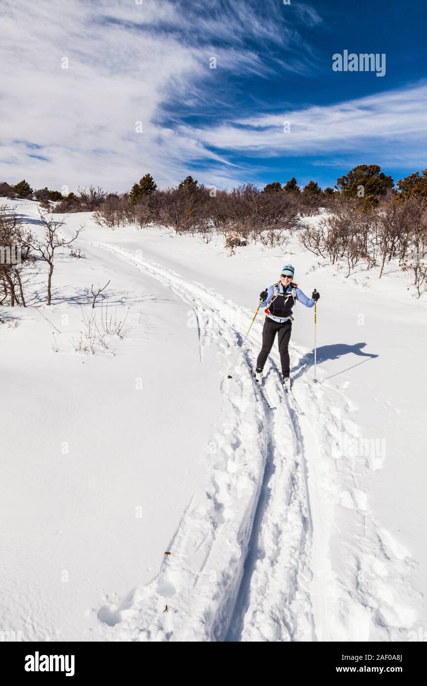 A middle aged woman cross country skiing in the foothills of the La Sal Mountains in southeast Utah, USA. Stock Photo