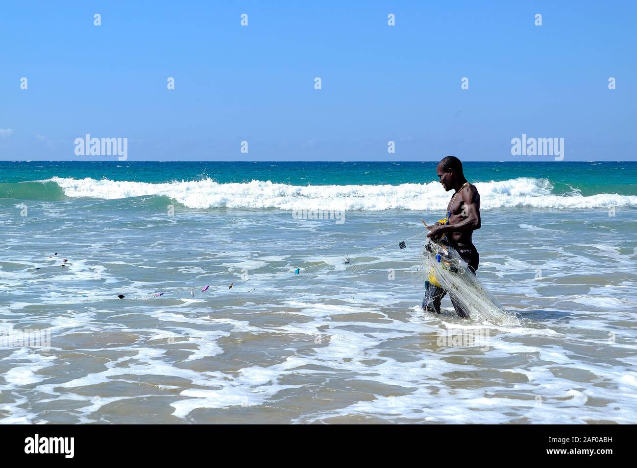 African fisherman in shallow water with his fishing net Stock Photo