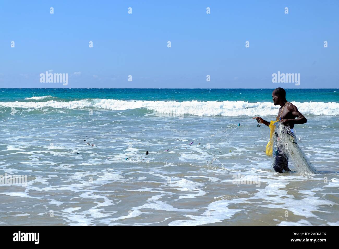 African fisherman in shallow water with his fishing net Stock Photo