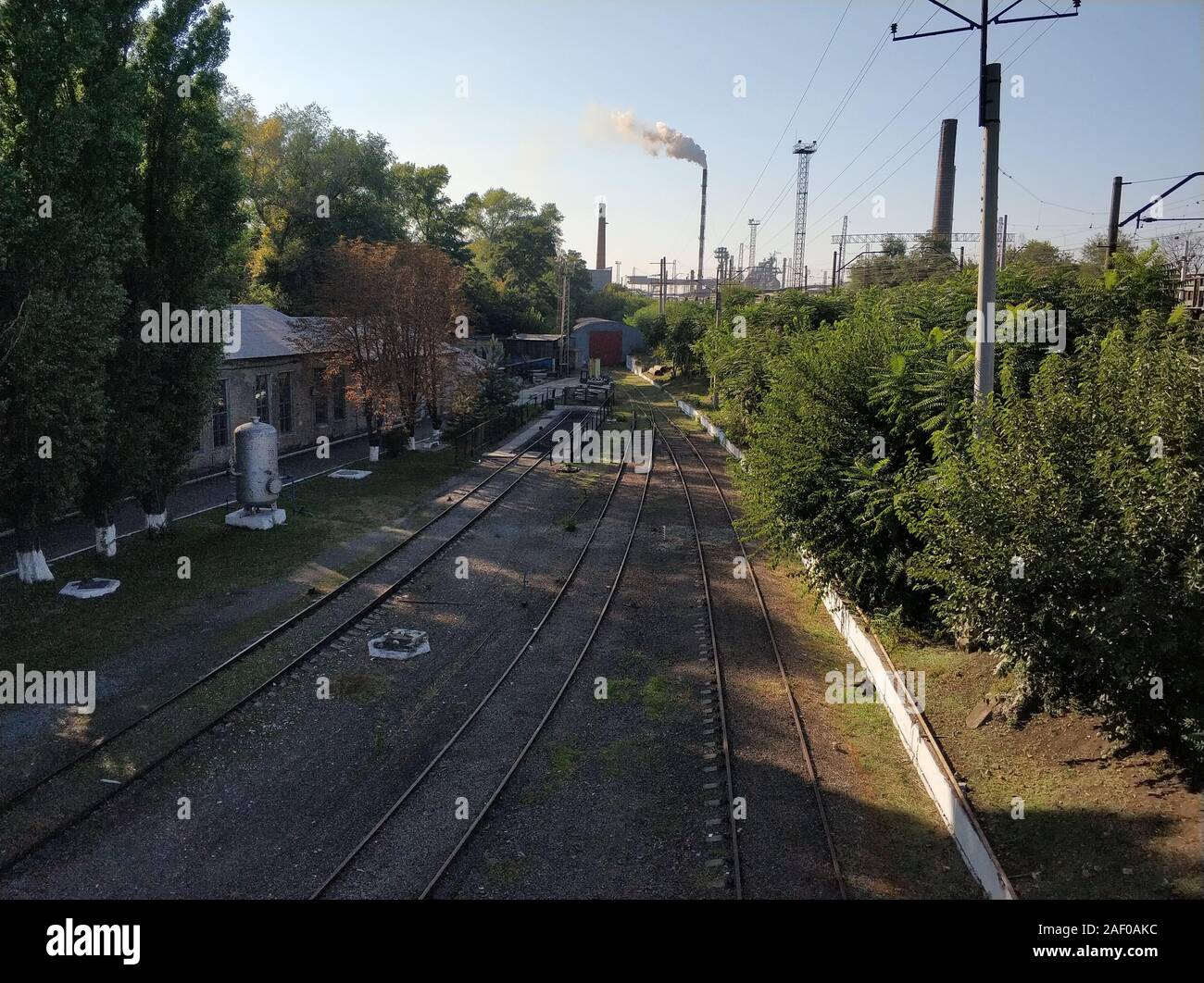 Empty Rails Railway. Empty rails on a background of smoking chimneys of a plant ...