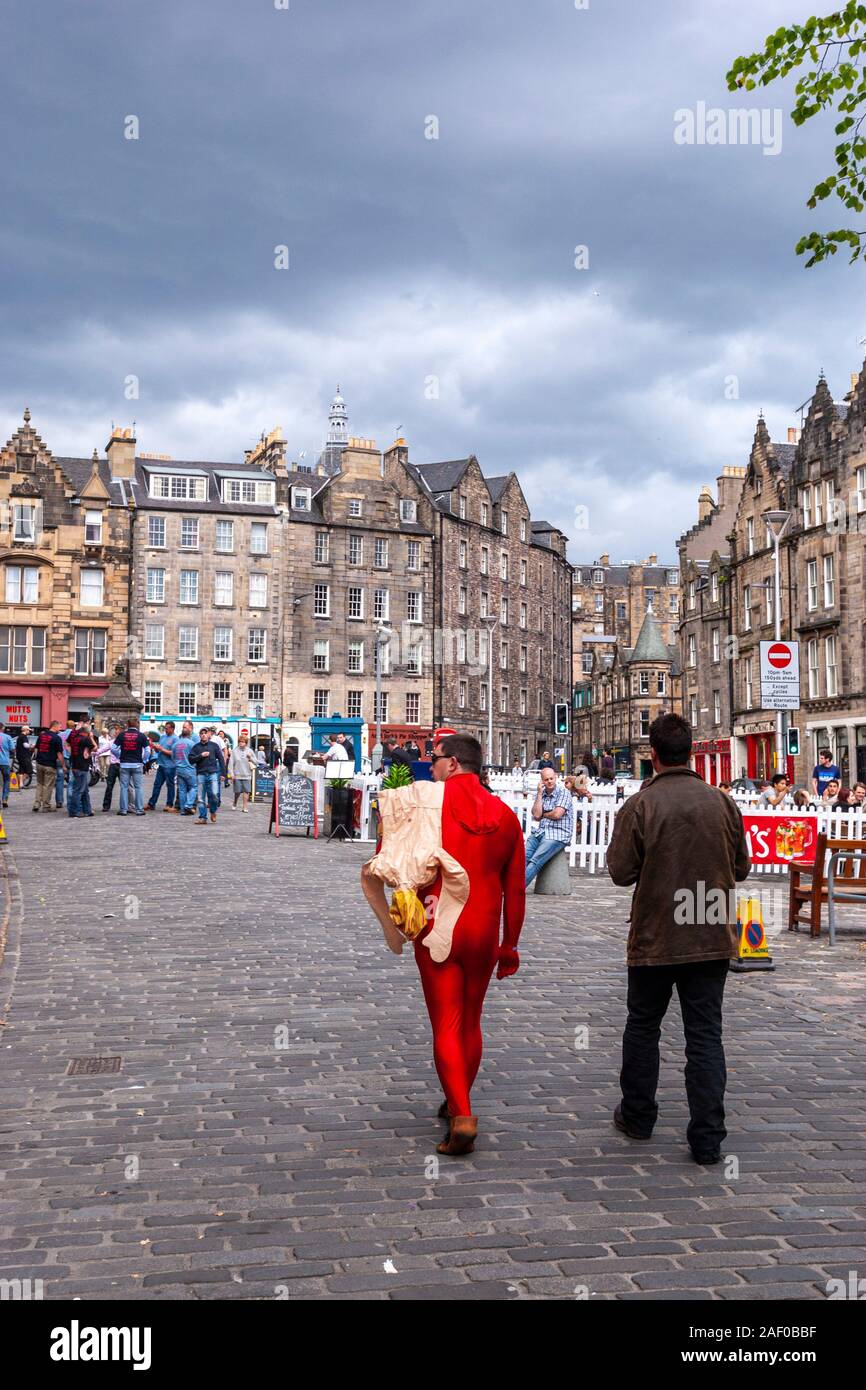 Red dressed man with an Inflatable Female Blow-up Doll , Grassmarket, market place , Edinburgh, Scotland, UK Stock Photo