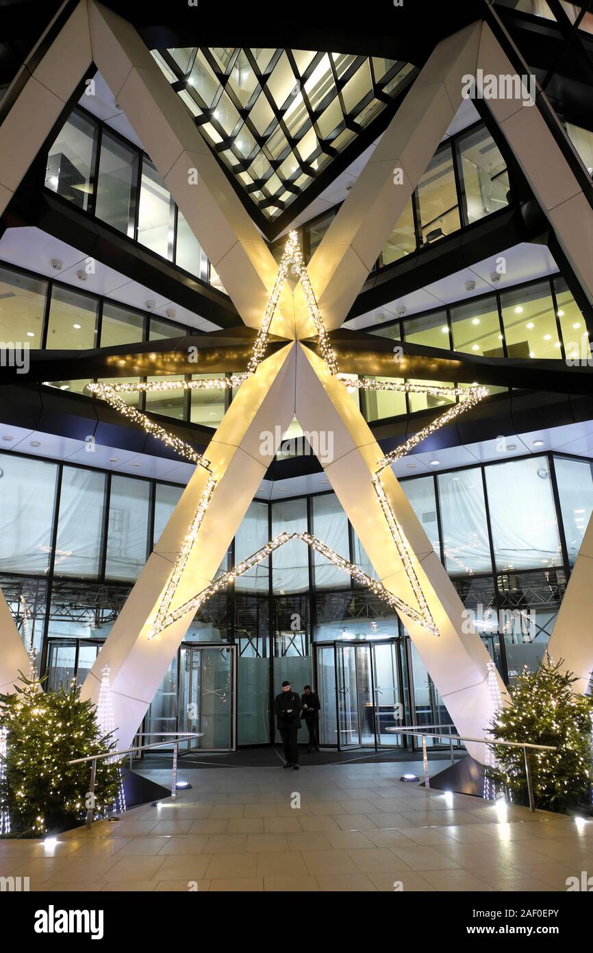 Christmas trees and star decoration outside the entrance to the gherkin skyscraper building in the financial district City of London UK  KATHY DEWITT Stock Photo
